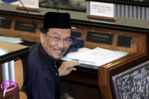 Malaysia's opposition figure Anwar Ibrahim acknowledges journalists as he sits after being sworn in as a member of parliament at the parliament house in Kuala Lumpur, August 28, 2008. Anwar won a sweeping victory in a by-election on Tuesday and returns to parliament just in time to join Friday's 2009 budget announcement and debate.