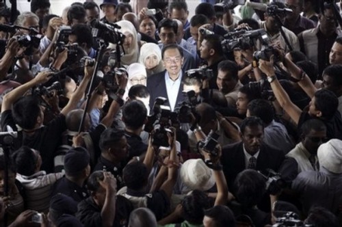 Malaysian opposition leader Anwar Ibrahim, center, is surrounded as he arrives at a court house in Kuala Lumpur, Malaysia, Wednesday, Sept. 10, 2008. (AP Photo/Lai Seng Sin)