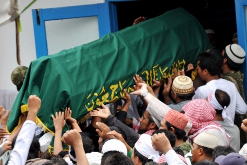 Supporters carry a coffin containing either Mukhlas or Amrozi (unclear) as they arrive at Al Islam boarding school in Tenggulun on November 9, 2008.  Grief and religious fervour boiled over into calls for revenge here as two brothers executed for their role in the 2002 Bali attacks were buried amid tight security.   A crowd of about 500 supporters briefly clashed with police near the family home of 47-year-old Amrozi -- dubbed the "smiling assassin" for his disturbing grin -- and Mukhlas, 48, as their bodies arrived in their east Java village. AFP PHOTO/ADEK BERRY (Photo credit should read ADEK BERRY/AFP/Getty Images)