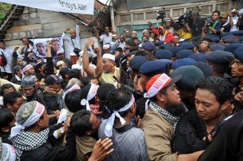Indonesian Mobile Brigade Policemen clash with supporters shortly before the funeral of the bodies of Amrozi and Mukhlas in Tenggulun on November 9, 2008. Grief and religious fervour boiled over into calls for revenge here as two brothers executed for their role in the 2002 Bali attacks were buried amid tight security.   A crowd of about 500 supporters briefly clashed with police near the family home of 47-year-old Amrozi -- dubbed the "smiling assassin" for his disturbing grin -- and Mukhlas, 48, as their bodies arrived in their east Java village. AFP PHOTO/ADEK BERRY (Photo credit should read ADEK BERRY/AFP/Getty Images)