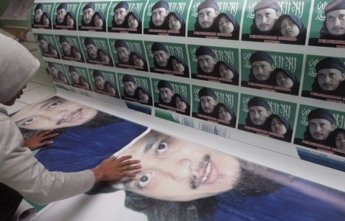 A worker monitors prints of posters of Bali bomber Imam Samudra with his daughter at a printing shop owned by Samudra's relative in Banten, West Java November 6, 2008. The attorney general's office has said the three militants-- Imam Samudra, Mukhlas and Amrozi--would be executed in early November for their role in the 2002 nightclub bombings on the resort island in which 202 people died. The writing on the posters read, "Mujahideen, fight".