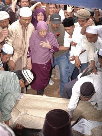 Emby Badriyah, center, looks on the coffin of her son, Bali bomber Imam Samudra, arrive at a cemetery in Serang, Banten province, Indonesia, Sunday Nov. 9, 2008. Indonesia executed Samudra, 38, and brothers Amrozi Nurhasyim, 47, and Ali Ghufron, 48, Saturday for helping plan and carry out the 2002 Bali bombings that killed 202 people, many of them foreign tourists. (AP Photo)