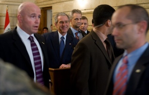 US President George W. Bush(2ndL), surrounded by security personnel, smiles after an Iraqi man threw his shoes at Bush during a joint press conference with Iraq's Prime Minister Nuri al-Maliki at Maliki's private office during an unannounced visit to Baghdad, Iraq, on December 14, 2008. The trip marks Bush's fourth visit to the country during his presidency. AFP PHOTO / Saul LOEB (Photo credit should read SAUL LOEB/AFP/Getty Images)