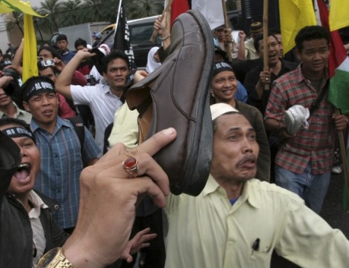 Muslim activists shows their shoes during a protest in front of the U.S. consulate in Medan, North Sumatra province, December 19, 2008. Dozens of activists gathered in protest to demand the release of Iraqi TV reporter Muntazer al-Zaidi, who threw his shoes at U.S. President George W. Bush during a recent news conference in Iraq, from jail. REUTERS/YT Haryono (INDONESIA)