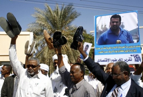 Journalists display their shoes and carry a poster of Iraqi journalist Muntazer al-Zaidi during a demonstration in Khartoum December 18, 2008. The journalists were taking part in the rally in support of al-Zaidi, who hurled his shoes at U.S. President George W. Bush during a news conference in Iraq on December 14, 2008. REUTERS/Mohamed Nureldin Abdallah (SUDAN)