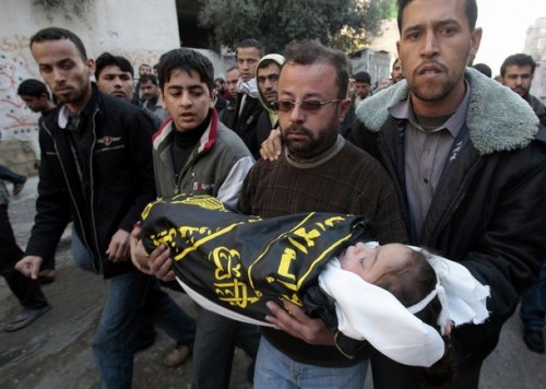 A Palestinian carries the body of his daughter who was killed during Israel's offensive, during her funeral in the northern Gaza Strip January 9, 2009. Israel pushed ahead with its two-week-old offensive in the Gaza Strip on Friday, defying a U.N. Security Council resolution calling for an immediate ceasefire.  REUTERS/Mohammed Salem (GAZA)