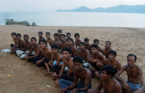 Rohingya migrants sit on a beach on Koh Sai Daeng in southwest Thailand while being processed by Thai authorities in this undated photo obtained by CNN. Pressure mounted on Thailand on January 26, 2009 to come clean on allegations the army towed Rohingya refugees out to sea and abandoned them in engine-less boats, after CNN showed pictures depicting exactly that.