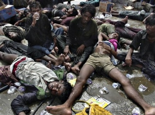 Ethnic Rohingya refugees lay sprawled on the ground after being rescued by Acehnese fishermen Jan. 7, 2009 on Sabang, an island off the coast of Banda Aceh, Indonesia.  One hundred ninety-three men of Rohingya ethnicity, 17 from Bangladesh and the others from Myanmar, allege that they were mistreated by Thai soldiers and then towed to sea and left to drift with inadequate supplies. (AP Photo/Taufik Kurahman)