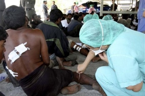 A wounded Rohingya migrant is treated by a Thai nurse at the provincial hospital in Ranong province, southern Thailand, Tuesday, Jan. 27, 2009. A new boatload of the 78 ethnic Rohingya migrants was detained in Thailand, several with lacerations, burns and other wounds they said were inflicted by Myanmar soldiers, Thai authorities said. (AP Photo)