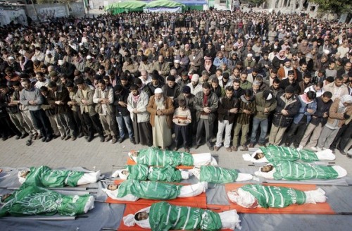 Mourners pray near the bodies of Palestinians killed after an Israeli air strike in the northern Gaza Strip January 4, 2009. Israeli soldiers and Palestinian militants battled on Gaza City's outskirts on Sunday after Israeli troops and tanks invaded the coastal enclave in the worst fighting in the conflict in decades.  REUTERS/Ismail Zaydah (GAZA)