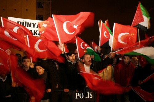 Supporters of Justice and Developpment Party (AKP) wave national and Palestinian flags as Turkish Prime Minister Recep Tayyip Erdogan arrives at Ataturk International Airport in Istanbul, early January 30, 2009. Erdogan stormed out of a debate with Israeli President Shimon Peres about the Gaza war at the Davos forum. AFP PHOTO / MUSTAFA OZER (Photo credit should read MUSTAFA OZER/AFP/Getty Images)