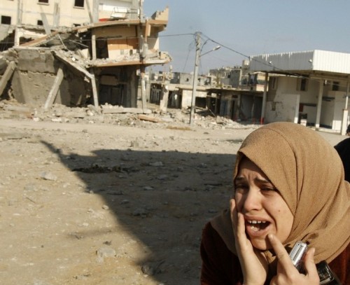 A Palestinian woman reacts after an Israeli air strike in Rafah in the southern Gaza Strip January 12, 2009. Israeli troops fought fierce gun battles with Hamas fighters on Monday, keeping military pressure on the Islamist group while avoiding all-out urban warfare that would complicate ongoing diplomatic efforts to end the Gaza war.  REUTERS/Ibraheem Abu Mustafa (GAZA)