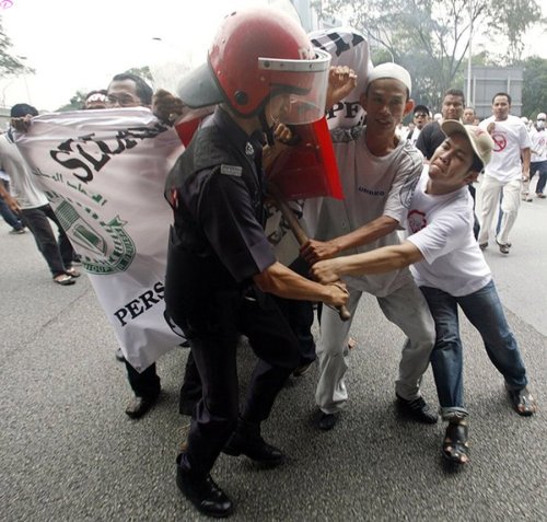 A riot policeman scuffles with demonstrators during a protest against the use of the English language in teaching science and mathematics at schools, in Kuala Lumpur March 7, 2009. Malaysian police fired tear gas to disperse hundreds of opposition activists demanding that science and math be taught in the national Malay language, witnesses said. Language is a sensitive issue for the country's majority Malays and represents the latest political battleground for incoming Prime Minister Najib Razak, who is already facing a challenge from a weakening economy.         REUTERS PICTURES