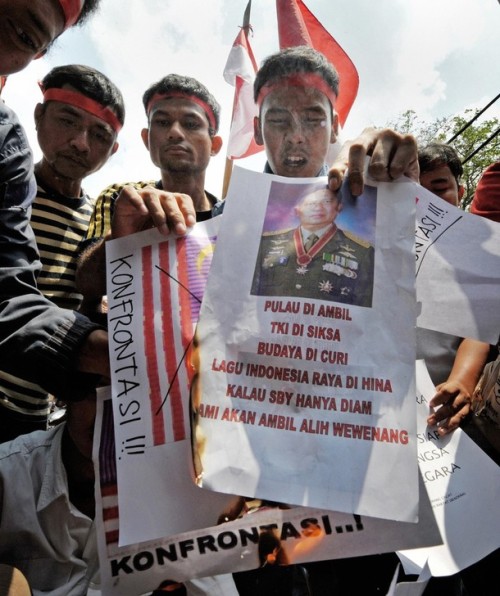 Indonesians burn pictures of the Malaysian flag as well as other placards during an anti-Malaysia protest in Jakarta on August 30, 2009 after the neighbouring country was accused of using Indonesian traditional dances to promote Malaysian tourism.  Indonesian President Susilo Bambang Yudhoyono has asked the Malaysian government to deal more carefully with "sensitive" cultural issues between the two countries, after a recent Malaysian tourism advertisement, a 30-second video clip, showed Balinese "Pendet" dancing.   AFP PHOTO / Bay ISMOYO (Photo credit should read BAY ISMOYO/AFP/Getty Images)
