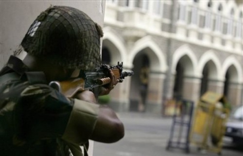 An Indian soldiers aims at Taj Mahal Hotel where suspected militants are holed up during an assault in Mumbai, India, Friday, Nov. 28, 2008. Explosions and gunfire continued intermittently at the Taj Mahal Hotel Friday afternoon,two days after a chain of militant attacks across India's financial center left people dead and the city in panic. (AP Photo/Altaf Qadri)